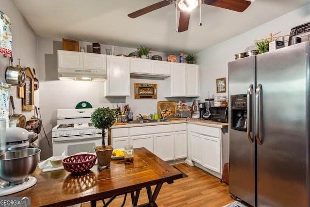 kitchen featuring white cabinetry, sink, stainless steel fridge, light hardwood / wood-style floors, and white gas range oven