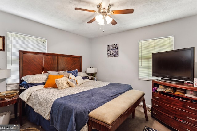 carpeted bedroom featuring ceiling fan and a textured ceiling