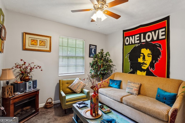 living room featuring ceiling fan, carpet flooring, and a textured ceiling