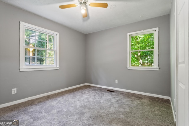 spare room featuring carpet floors, a healthy amount of sunlight, and ceiling fan