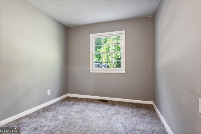 carpeted spare room with a textured ceiling