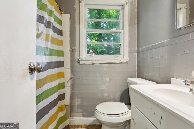 bathroom with vanity, curtained shower, tile walls, and toilet