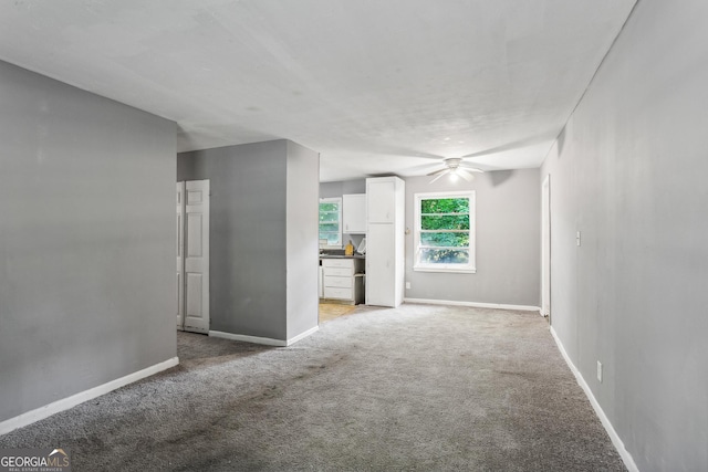 interior space featuring light colored carpet and ceiling fan