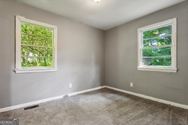 unfurnished room with plenty of natural light and carpet