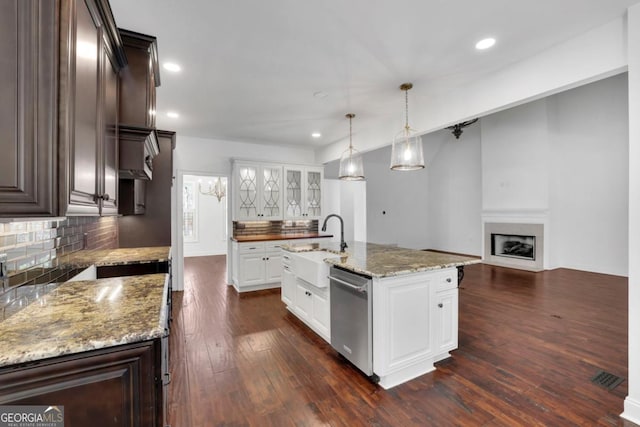 kitchen featuring an island with sink, stainless steel dishwasher, white cabinets, and dark brown cabinetry