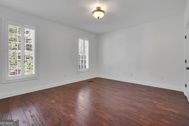 spare room with dark hardwood / wood-style flooring