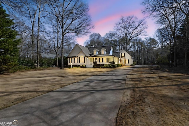 cape cod house featuring a porch