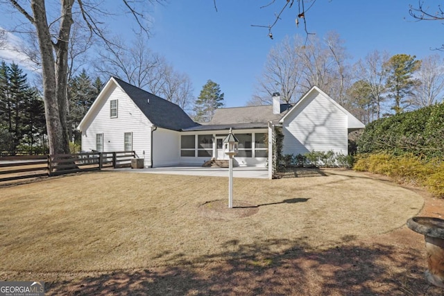 back of property featuring a patio, a sunroom, and a lawn