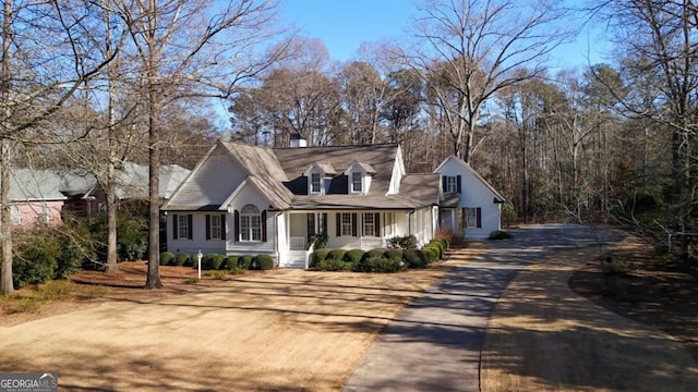 cape cod home featuring covered porch