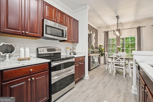 kitchen with pendant lighting, stainless steel appliances, crown molding, light stone countertops, and light wood-type flooring