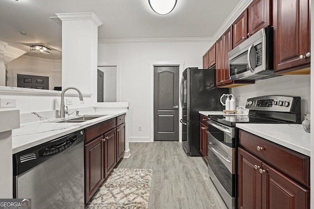 kitchen with sink, appliances with stainless steel finishes, ornate columns, ornamental molding, and light wood-type flooring