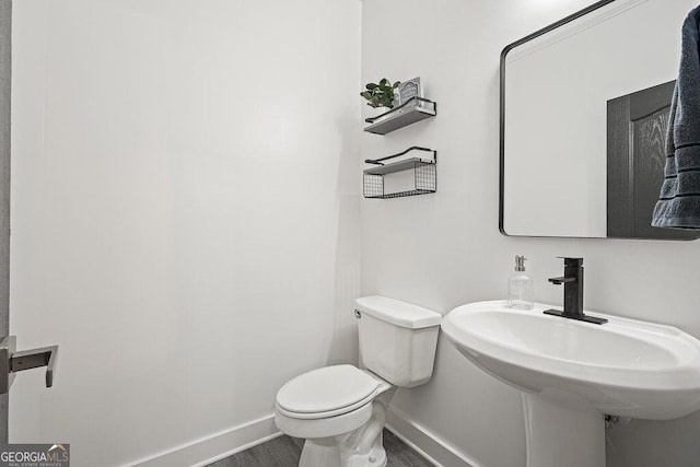 bathroom with sink, hardwood / wood-style floors, and toilet