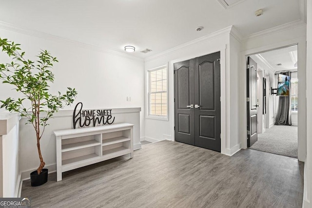 foyer entrance with hardwood / wood-style flooring and ornamental molding