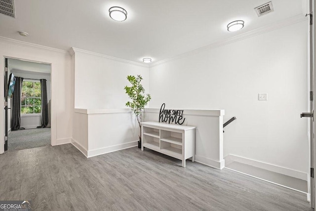 interior space featuring ornamental molding and light wood-type flooring