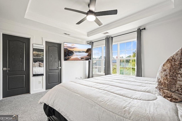 bedroom with ceiling fan, ornamental molding, carpet flooring, and a raised ceiling