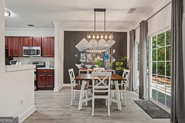 dining room featuring an inviting chandelier, light hardwood / wood-style flooring, and ornamental molding