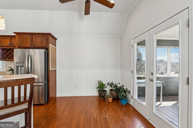 kitchen with stainless steel refrigerator with ice dispenser, french doors, lofted ceiling, ornamental molding, and dark hardwood / wood-style floors