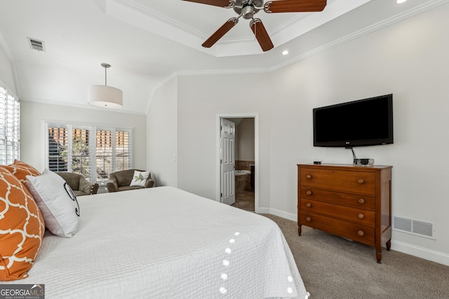 carpeted bedroom featuring ceiling fan, ornamental molding, a tray ceiling, and ensuite bathroom