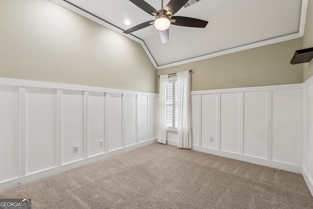 spare room with crown molding, vaulted ceiling, light colored carpet, and ceiling fan