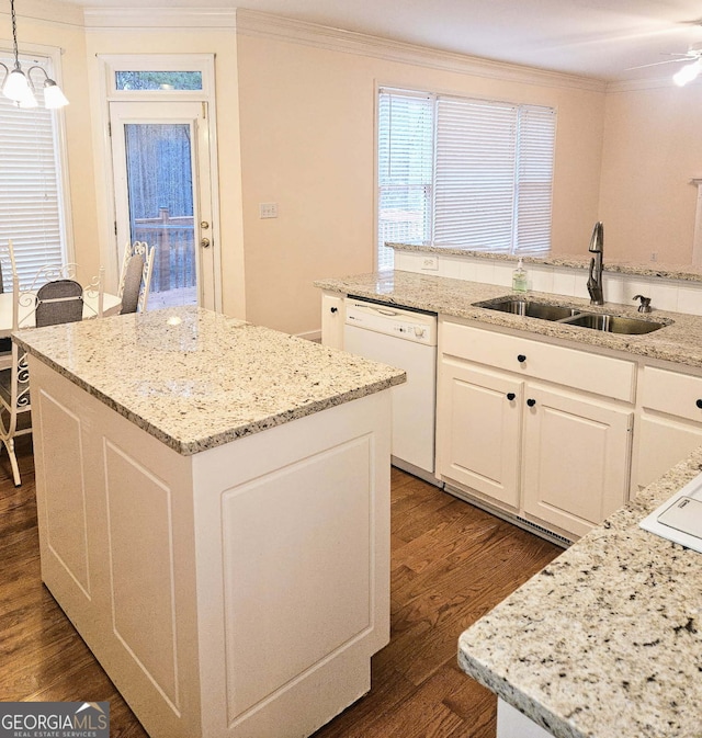 kitchen with a center island, decorative light fixtures, a sink, and white dishwasher