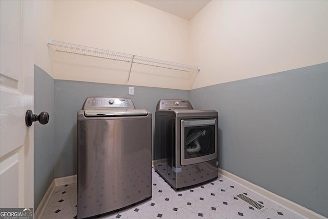 laundry room with laundry area, washing machine and clothes dryer, and baseboards