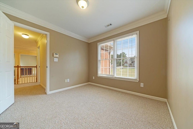 carpeted spare room featuring baseboards, visible vents, and crown molding