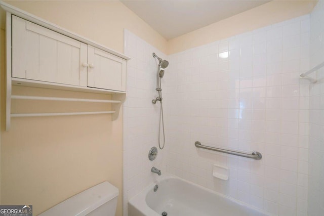 bathroom featuring tiled shower / bath and toilet