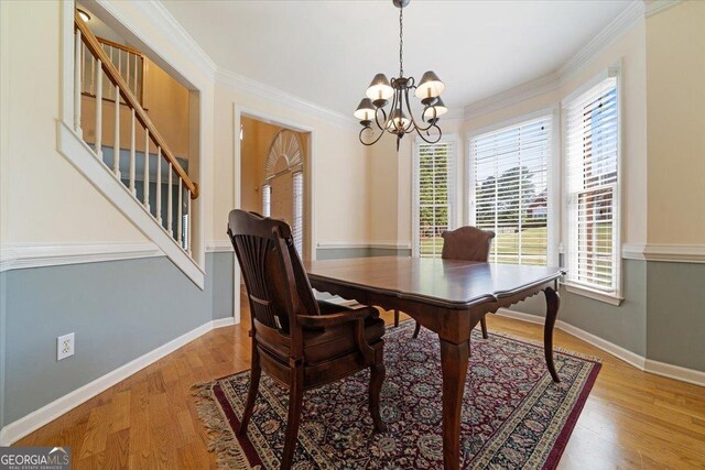 dining room with a notable chandelier, hardwood / wood-style flooring, and ornamental molding