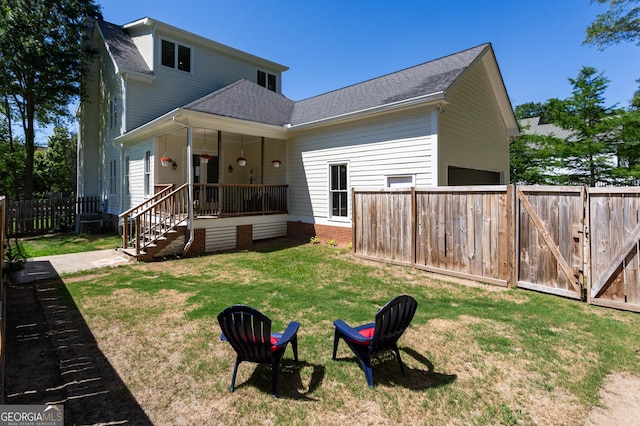 back of house with a yard, a fenced backyard, a gate, and roof with shingles