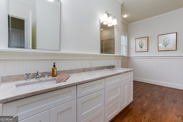 bathroom featuring vanity, wood-type flooring, and ornamental molding