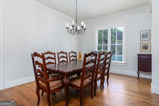 dining space with an inviting chandelier, hardwood / wood-style floors, and ornamental molding