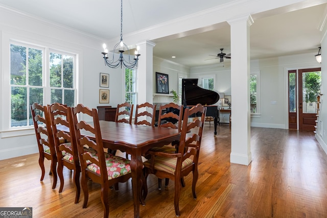 dining room with plenty of natural light, decorative columns, and wood-type flooring