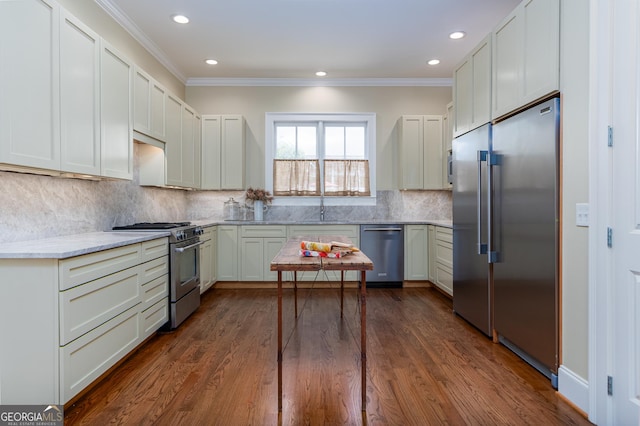 kitchen with appliances with stainless steel finishes, ornamental molding, and recessed lighting
