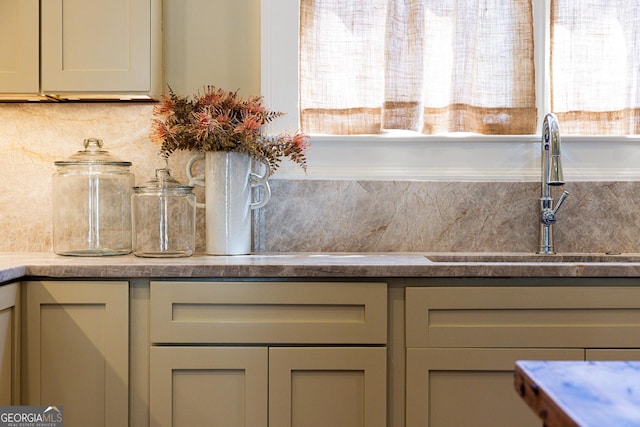 details with gray cabinets, a sink, and backsplash