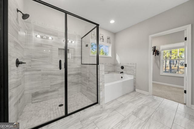 bathroom featuring plus walk in shower and plenty of natural light