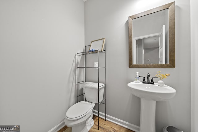 bathroom with hardwood / wood-style floors, sink, and toilet