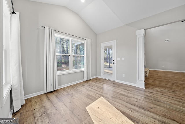 empty room with lofted ceiling and light hardwood / wood-style flooring