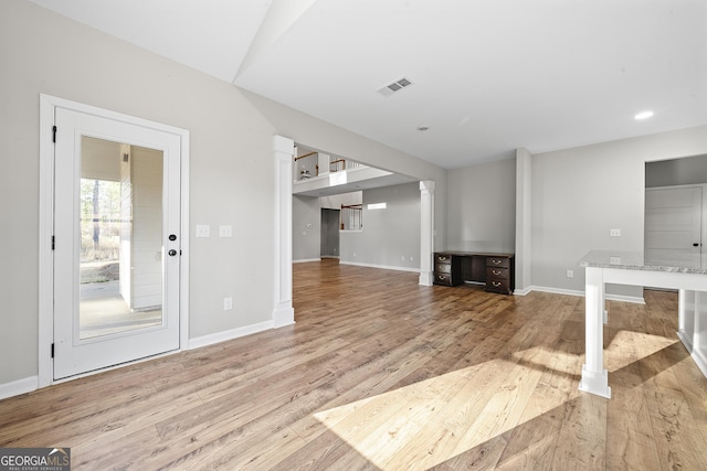 unfurnished living room with light hardwood / wood-style floors and decorative columns