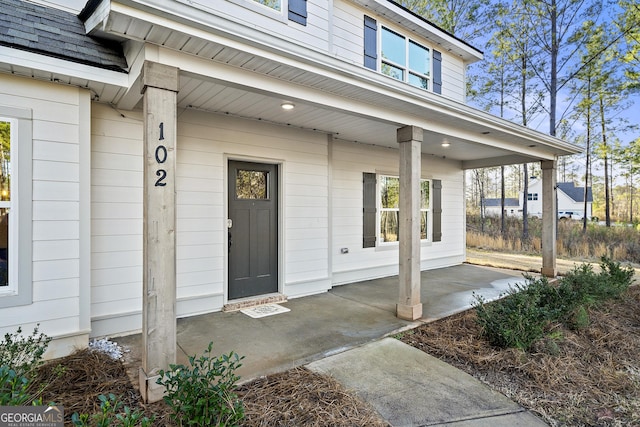 view of exterior entry featuring covered porch