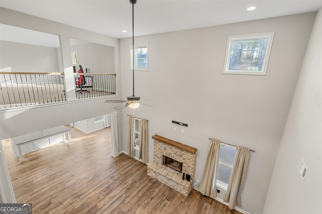 living room featuring a brick fireplace, hardwood / wood-style floors, and ceiling fan