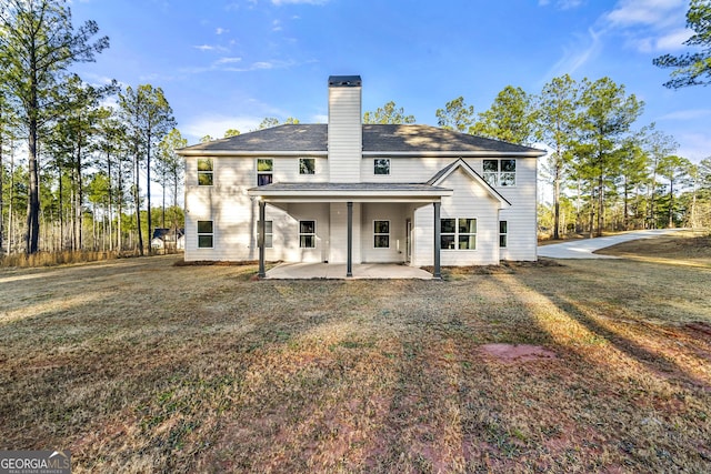 rear view of house with a lawn and a patio