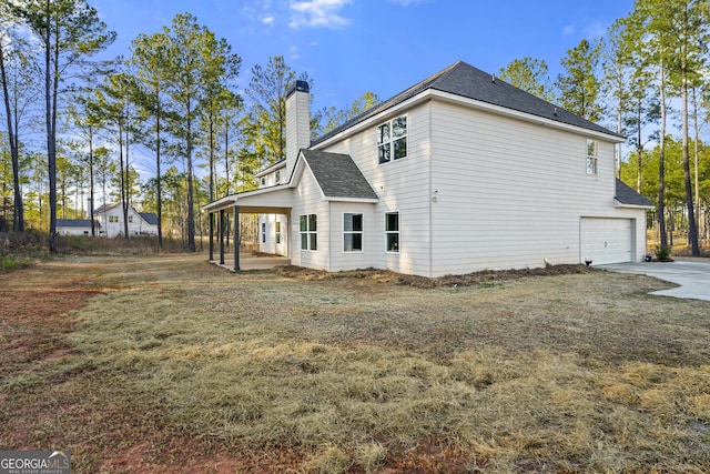 back of property with a garage and a lawn