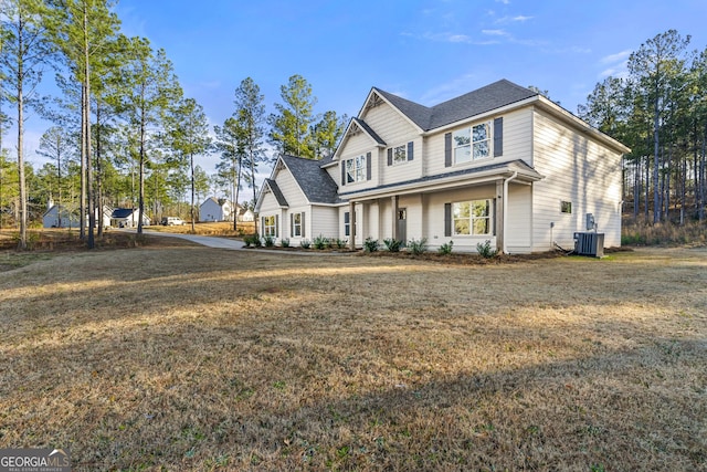 view of front of property featuring central AC unit and a front yard