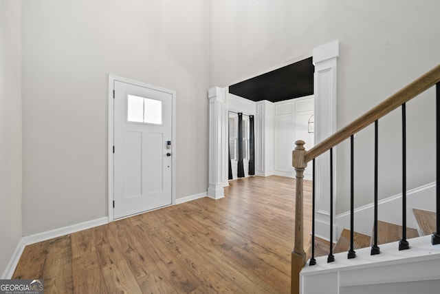 entryway with hardwood / wood-style flooring and a towering ceiling