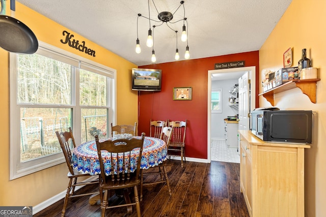 dining space with dark hardwood / wood-style floors and a textured ceiling