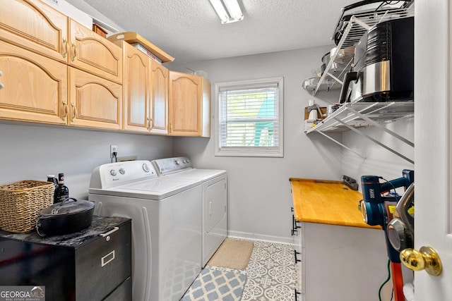 clothes washing area with washer and clothes dryer, cabinets, and a textured ceiling