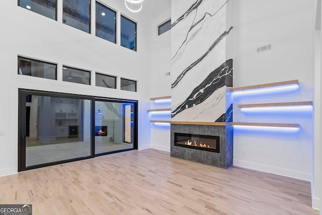 unfurnished living room featuring a high ceiling and wood-type flooring