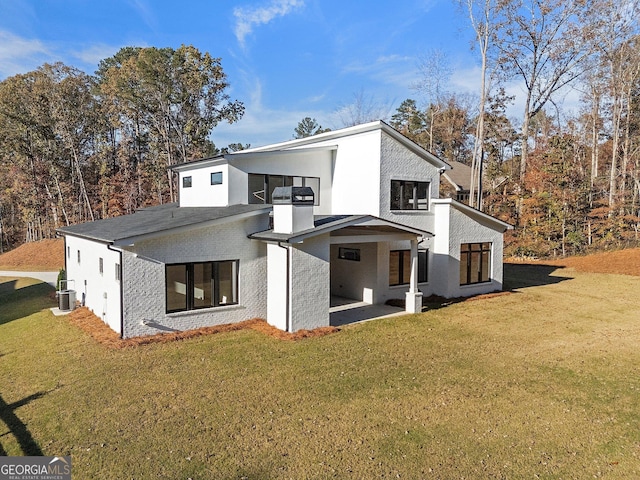 rear view of house with cooling unit, a patio area, and a lawn