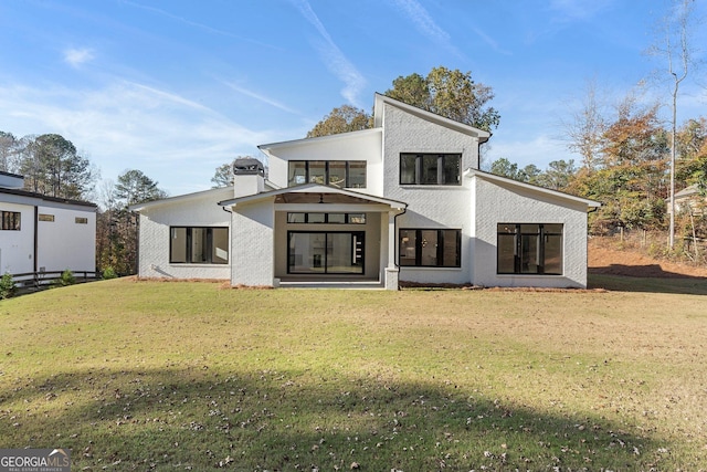 rear view of house featuring a yard