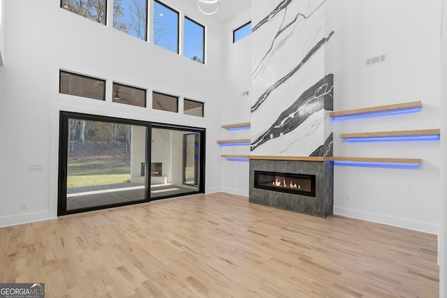 unfurnished living room featuring a fireplace, a healthy amount of sunlight, and light wood-type flooring